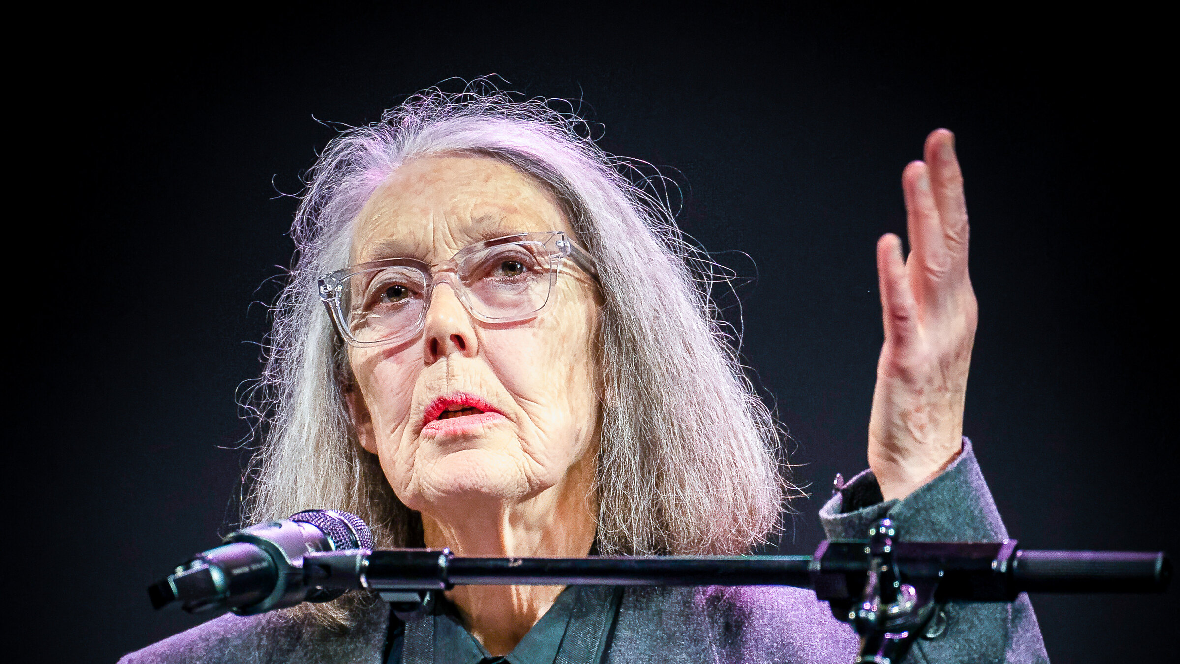 Anne Carson speaking at a lectern