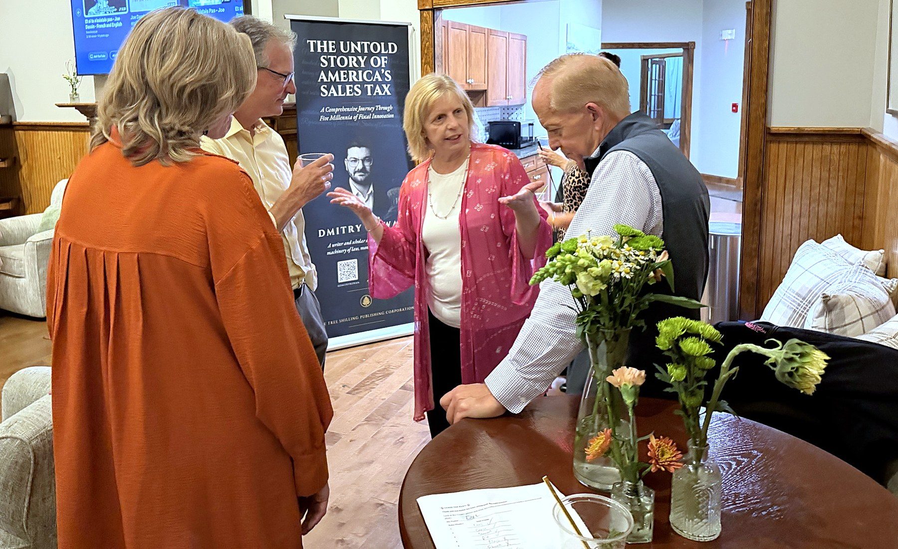 Guests in conversation in front of the banner for The Untold Story of America's Sales Tax