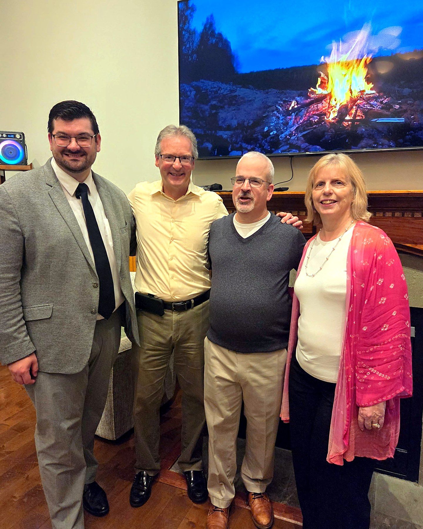 Dmitry Rowan with guests beside the fireplace