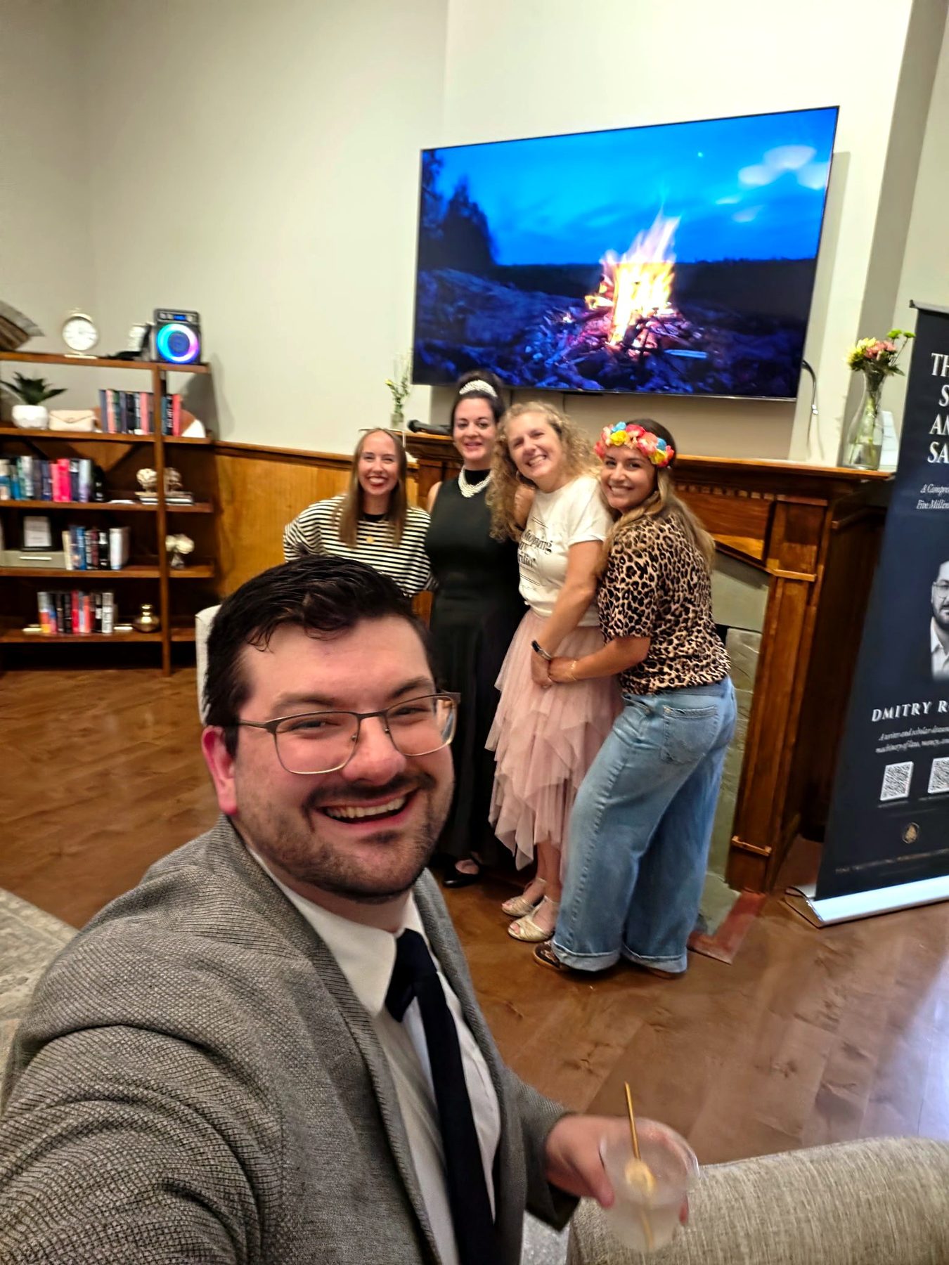 Dmitry Rowan taking a photograph with guests by the fireplace